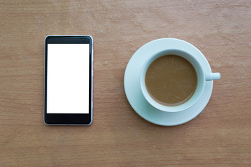 Fototapeta na wymiar Smartphone and coffee cup on wooden desk