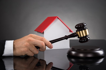 Judge With House Model Hitting Gavel