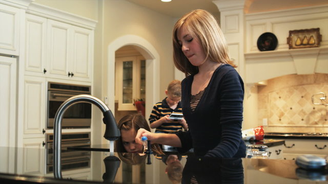 children in the kitchen washing the dishes