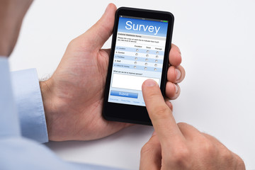 Person Filling Survey Form On Mobile Phone