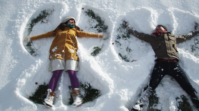 young couple making snow angels