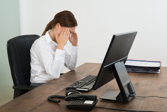 Businesswoman Having Head Pain In Office
