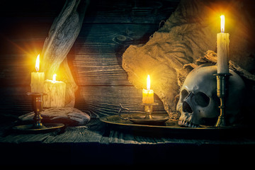 On wooden background skull and candles