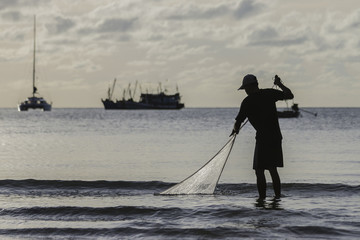 the fisherman he is casting fishing on the seaside