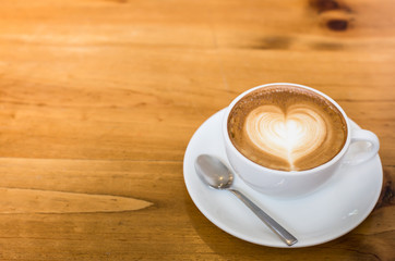 Hot art Latte Coffee in a cup on wooden table.