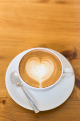 Hot art Latte Coffee in a cup on wooden table.