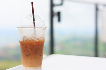 Iced coffee with straw in plastic cup with nature background