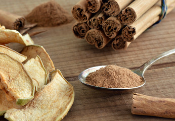 Ceylon Zimt - Zimtpulver auf L&ouml;ffel / Mit D&ouml;rr&auml;pfeln auf Holz