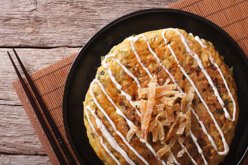 Japanese okonomiyaki on a table close-up. Horizontal top view
