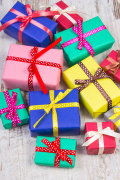 Wrapped colorful gifts for Christmas or other celebration on old white plank
