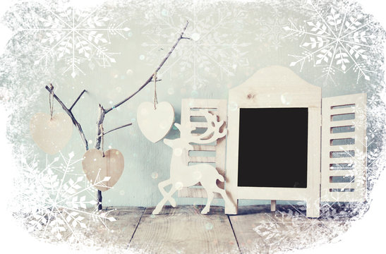 decorative chalkboard frame and wooden hanging hearts over wooden table