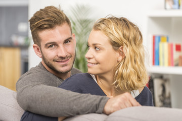 cheerful couple relaxing in sofa at home