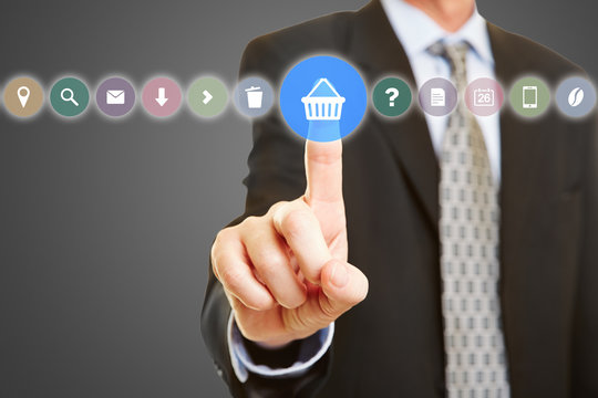 Hand w&auml;hlt Warenkorb auf Touchscreen