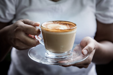 woman hand holding cup of coffee in morning time,selective focus