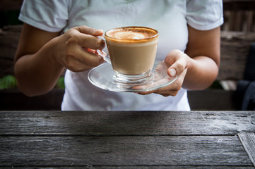 woman hand holding cup of coffee in morning time,selective focus