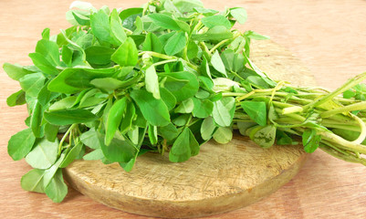 Fenugreek leaves on a wooden table.