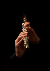 Fototapeta premium Hands of man playing a flute on a black background
