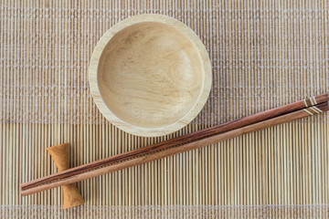 Chopsticks and empty wooden plate on  table setting