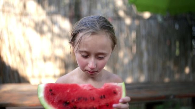 Happy little girl eating melon