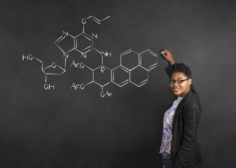 African American woman teacher writing science on chalk black board background