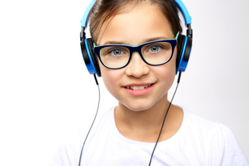 Dziewczynka w słuchawkach na uszach - obrazy, fototapety, plakaty