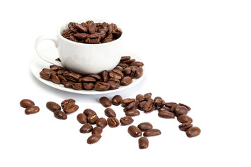 Coffee beans and ceramic cup on white background.