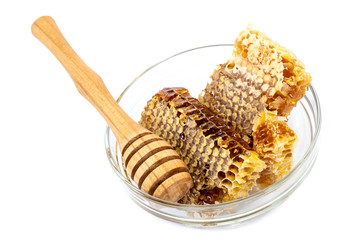 Comb honey in a bowl glass on white background.