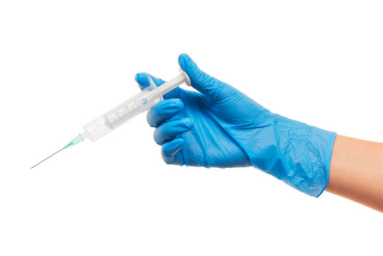 Close up of female doctor's hand in blue sterilized surgical glove with plastic medical syringe against white background