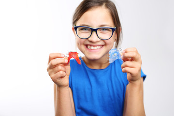 Zdrowy, piękny uśmiech, dziecko z aparatem ortodontycznym .Dziewczynka z kolorowym aparatem ortodontycznym  - obrazy, fototapety, plakaty