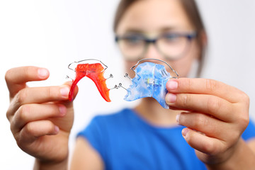 Dziewczynka z kolorowymi aparatami ortodontycznymi  - obrazy, fototapety, plakaty