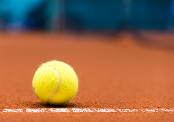 tennis ball on a red clay court