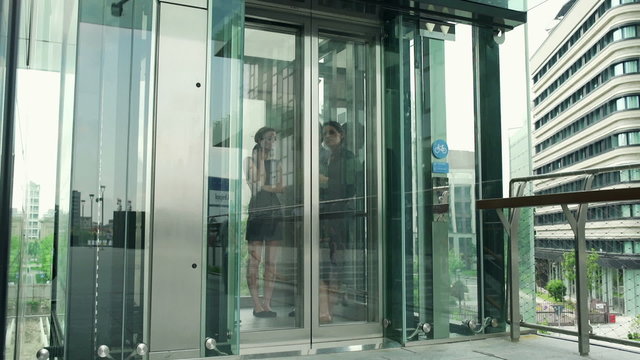 Businesspeople using elevator and walking out, steadycam shot
