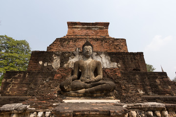 Buddha meditation in front of broken pagoda