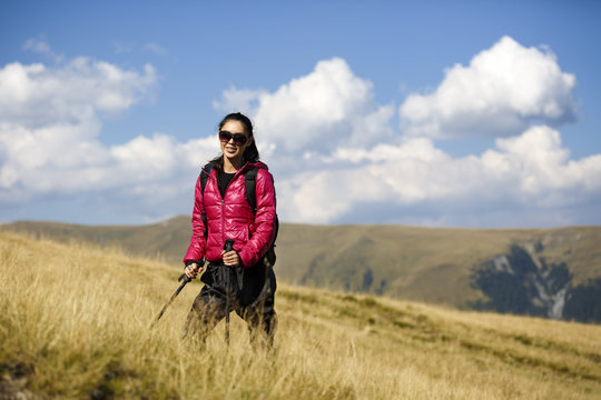 Woman Traveler with Backpack hiking in Mountains with beautiful