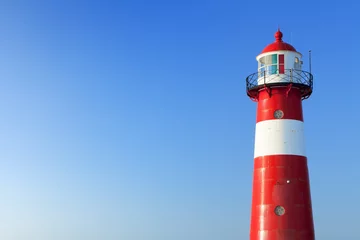 Wall murals Lighthouse Red and white lighthouse and a clear blue sky