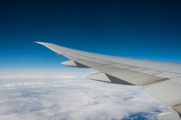 Wing of an airplane flying above the clouds.