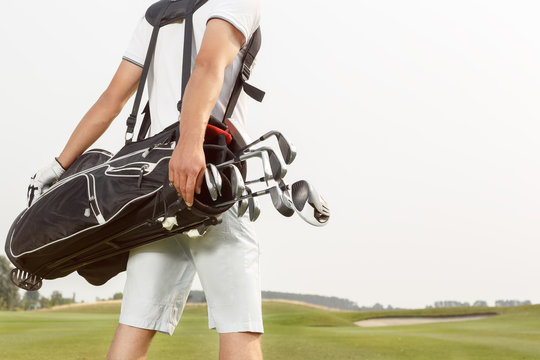 Man Carrying His Golf Bag Across Course