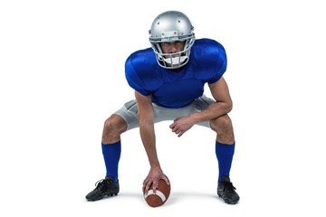 Full length of American football player placing ball