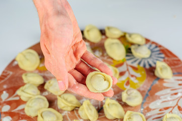 Man hands and raw dumplings with meat