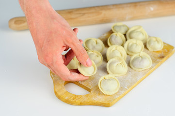 Man hands and raw dumplings with meat