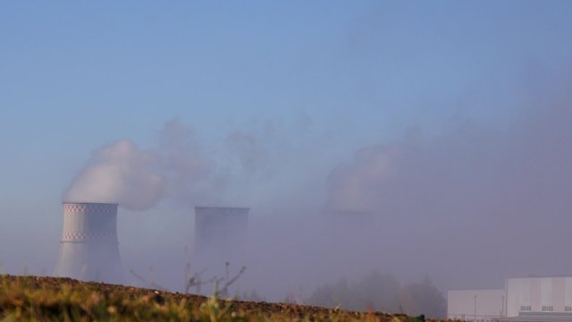 Grey smoke comes from chimneys in the sky