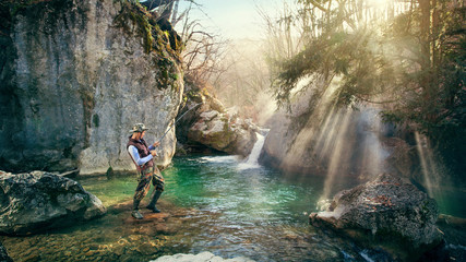 Fisherman catches fish in river. Fishing on beautiful nature with a waterfall