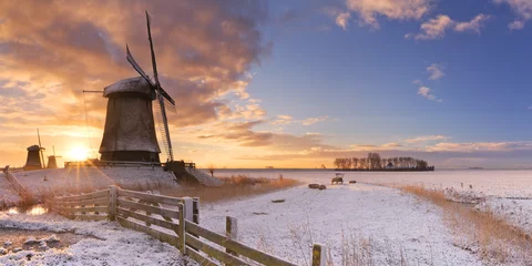 Abwaschbare Fototapete Traditionelle holländische Windmühlen im Winter bei Sonnenaufgang © sara_winter