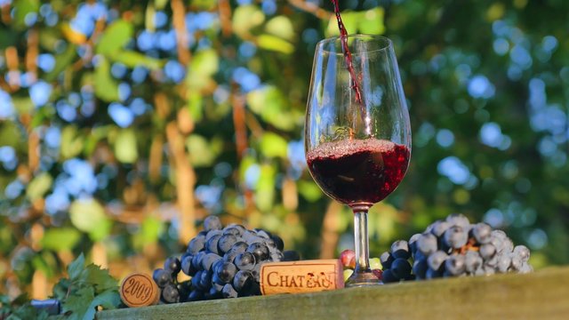 Pouring red wine into a wineglass outdoor