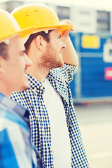 group of smiling builders in hardhats outdoors