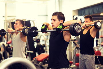 group of men with barbells in gym