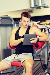 Fototapeta na wymiar young man with tablet pc computer in gym