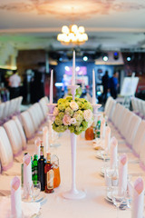 Nice flowers with candles in vase on the table in a restaurant in wedding day