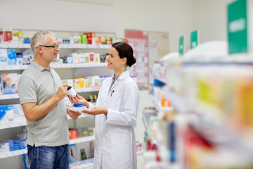 Fototapeta na wymiar pharmacist and senior man buying drug at pharmacy