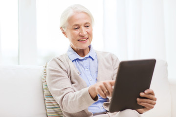 Fototapeta na wymiar happy senior woman with tablet pc at home
